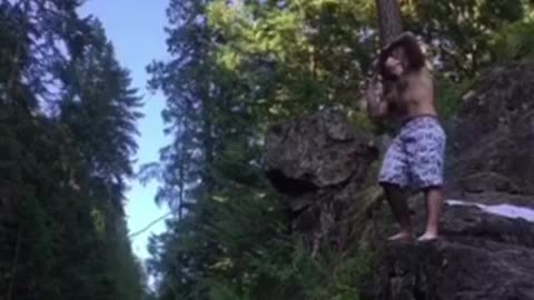 White sorts jumps from rocks into river epic belly flop