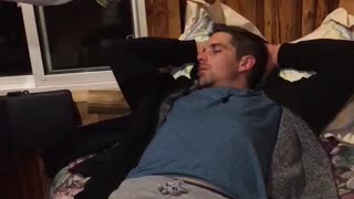 Guy in blue shirt laying down wakes up from noise
