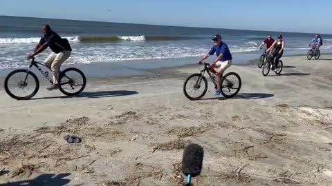 Biden ignores questions from the reporters and goes for a bike ride on the beach in South Carolina.