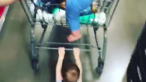 Kid holding onto shopping cart dragged across floor