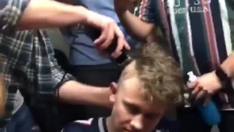 Guys recording friend shave patriots jersey friends head