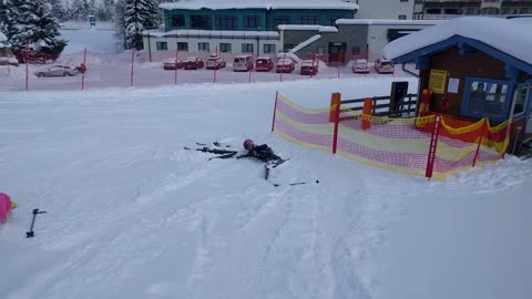 Red helmet kid ski wipeout snow