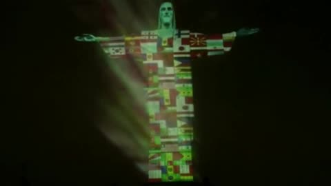 The Christ redeemer statue illuminated with world flags