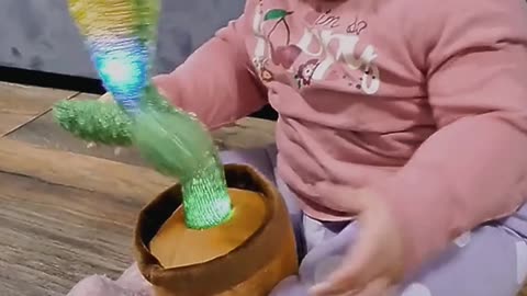 baby playing with cactus toy