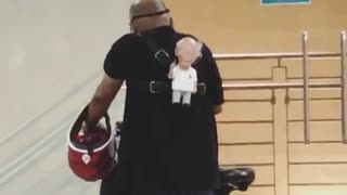 Man with old man stuffed toy on his back