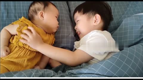 Precious moment of little sister and brother lying on bed looking each other