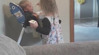 Little lady feeding her baby brother