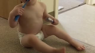 Baby chews on toothbrush and knocks herself over