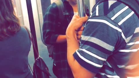 Man kissing pole in subway car