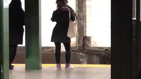 Woman dances in subway station while waiting for her train