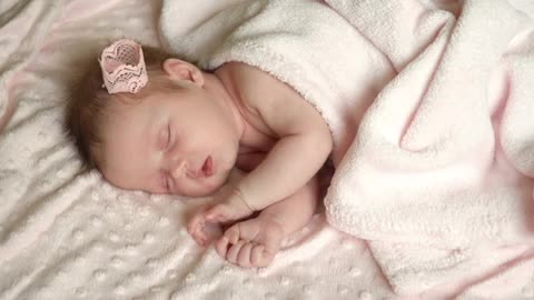 Newborn little baby girl is sleeping on the bed