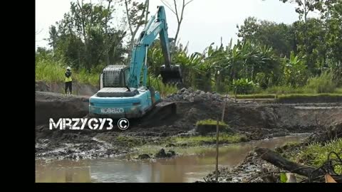 Excavators trucks digging large pond kobelco SK 200