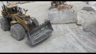 Driving a forklift to move large rocks on a quarry construction