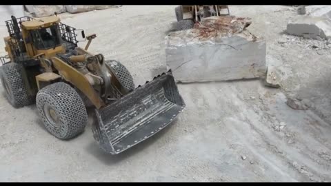 Driving a forklift to move large rocks on a quarry construction