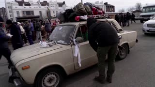 Exhausted, scared Ukrainians fleeing shelling arrive near Kyiv