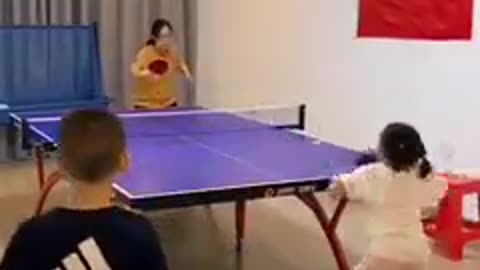 young child playing table tennis
