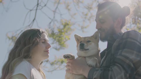 Couple Kissing Their Pet Dog