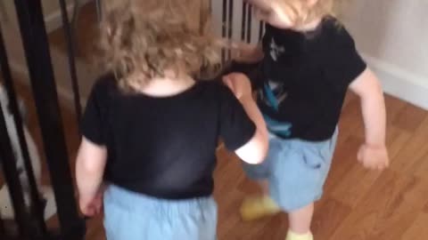 Twins discover priceless way to share slippers
