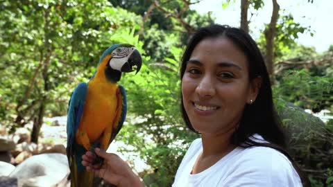 A woman smiling while holding a parrot