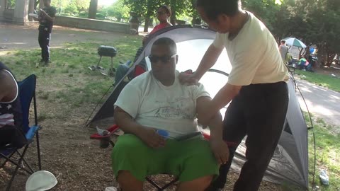 Luodong Briefly Massages Black Man In Green Shirt At Picnic