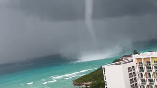 Waterspout Towers Over Shore