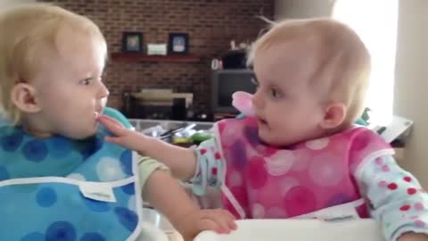 Twins biting each other fingers