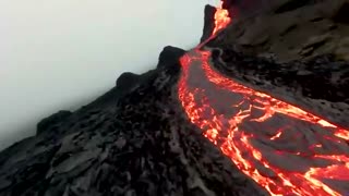 Spectacular drone footage flying over lava fields and an erupting volcano in Iceland by