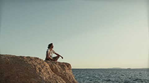 Man Sitting On Cliffside