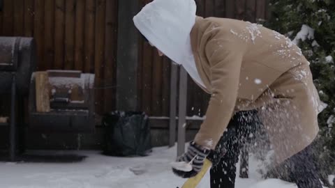 Man Chopping Firewood Under Blizzard