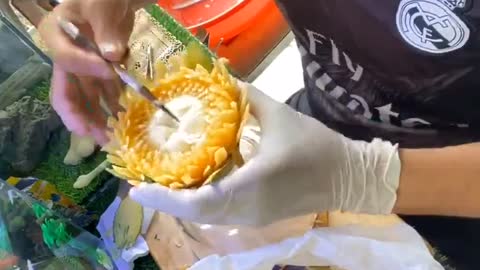 Watch this artist intricately carve beautiful floral pattern into a papaya