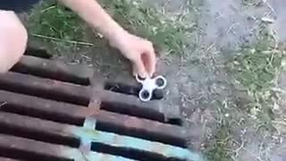 Kid drops white fidget spinner in drain