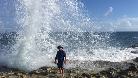 Prankster wife tricks husband into getting splashed by wave