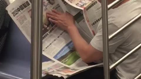 Man holds and touches a picture on a newspaper