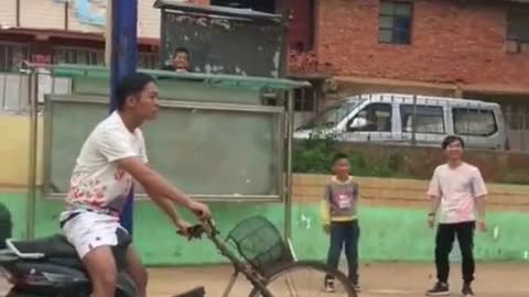 Basketball player jumps and lands on guy's bike tire...poor bike tire