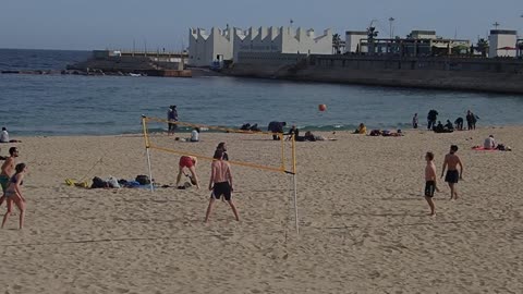 Two Teams Play Volleyball Game At The Beach