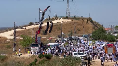Zionist settlers celebrate dancing near the burning Strip