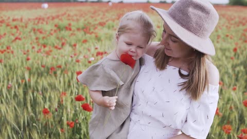 Cute little girl walking in The Flower Field With Her Mom