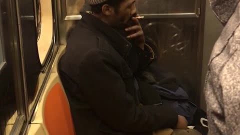 Man smokes in the corner seat on subway train