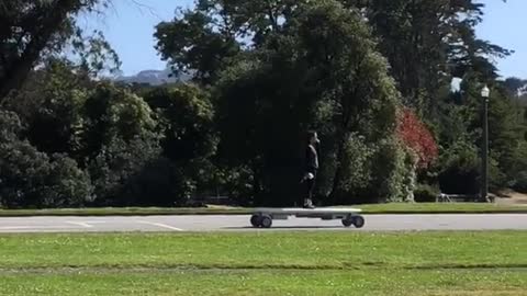 Girl at golden gate park rides a huge motorized skateboard