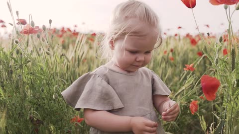 Girl Smelling Red Poppy Flower