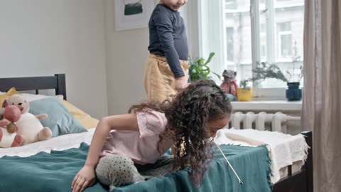 Kids Playing Catch The Bait With Their Cat In The Bedroom