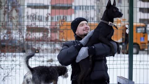 Happy man hugging two funny dogs at winter outdoor