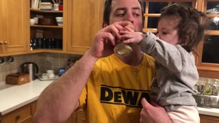 Baby girl is desperate for a sip of daddy’s drink