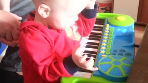 Little boy falls playing toy piano