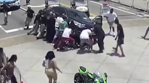 Onlookers & Police Come to the Rescue of Motorcyclist Trapped Beneath a Car