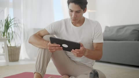 Young man watching yoga videos for practice