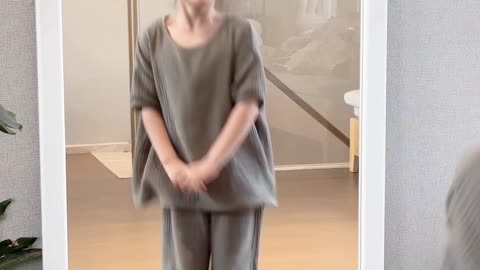 cute baby dancing in front of mirror in simple home outfit