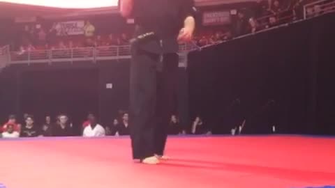 Guy black karate uniform spinning nunchucks backflip fail