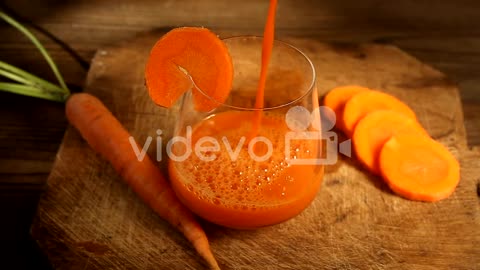 Carrot juice in glass on table