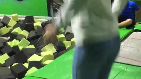 Guy slips and fails at green trampoline park
